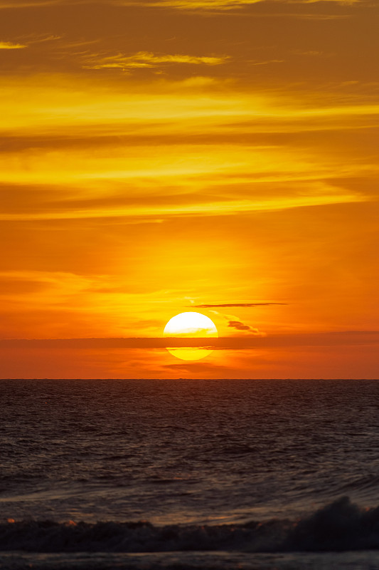 在黄金时间日落时，海面上的落日图片素材