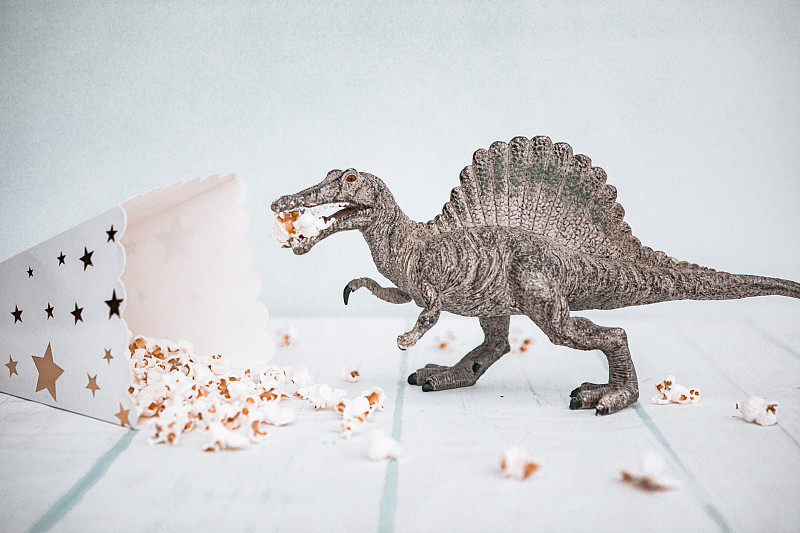 拍摄恐龙玩具吃爆米花图片素材