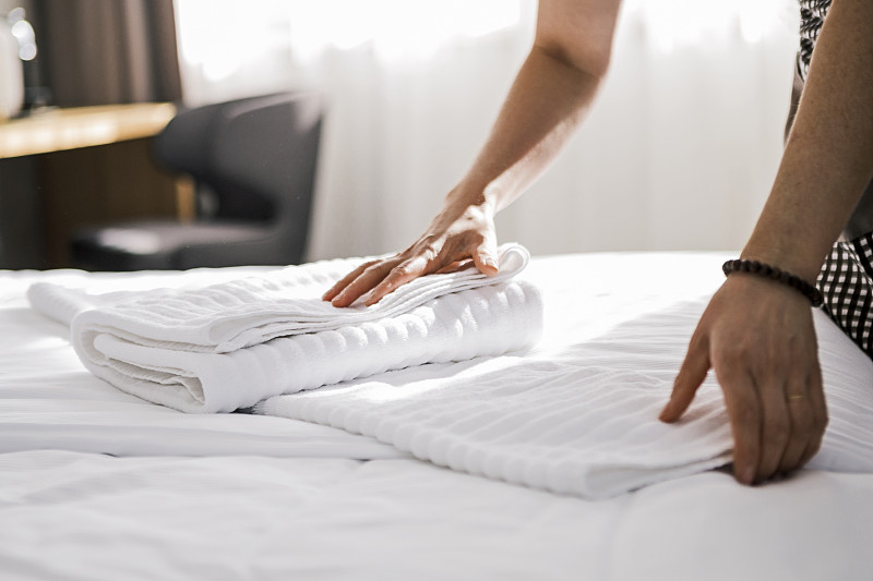 酒店客房清洁时使用干净的毛巾图片素材