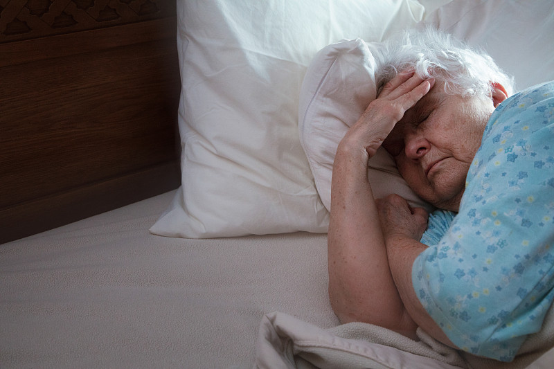 生病的老妇人躺在床上想睡觉图片素材