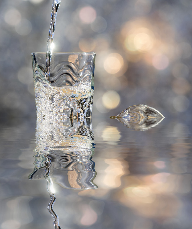 一杯水晶与水的冲击，落在水中反射。图片素材