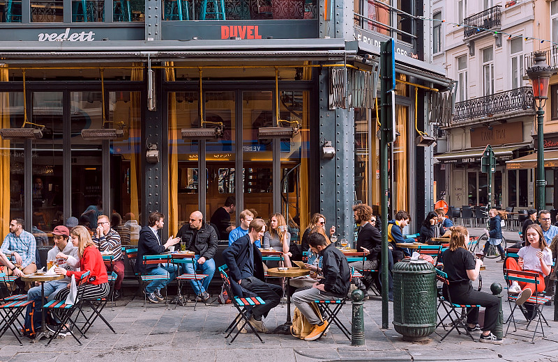 一群快乐的人在繁忙的晚上聚集在街头的咖啡馆区喝酒图片下载