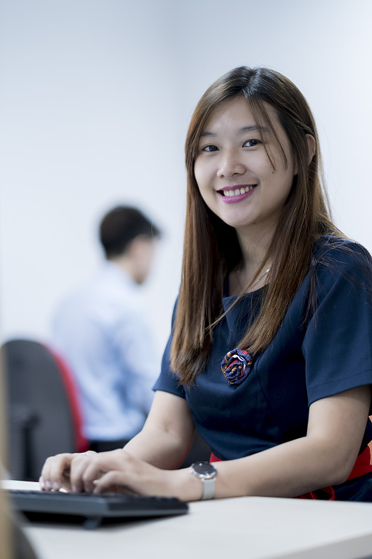 一位亚洲白领坐在她的办公桌前图片素材