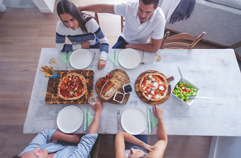 家人或朋友坐在餐桌前摆好带走的食物。图片素材