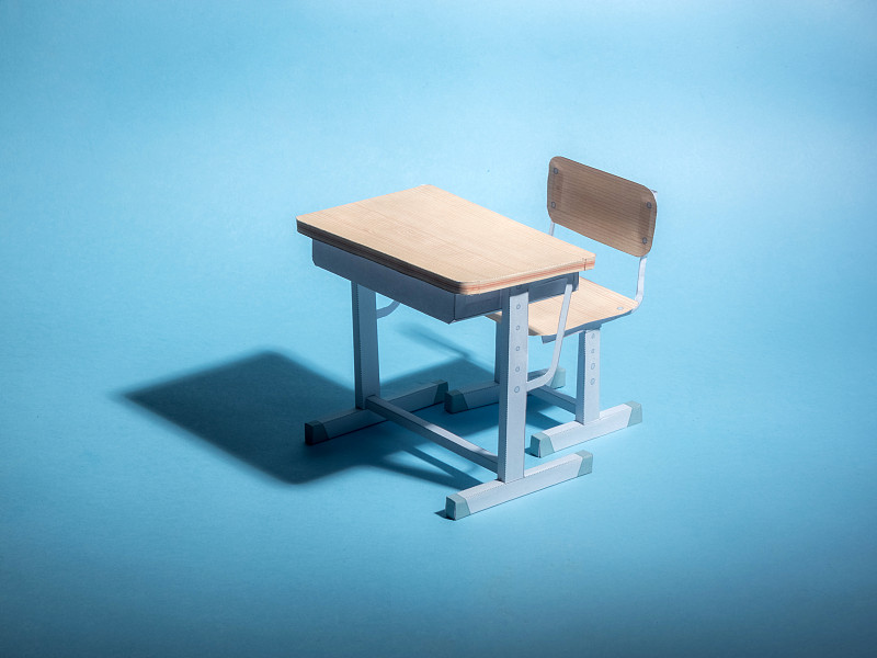蓝色背景下的空课桌。概念。图片下载