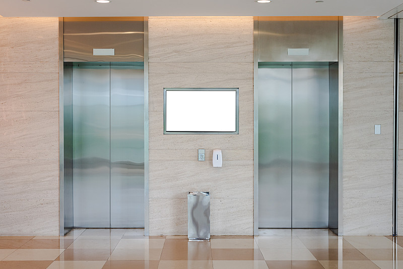 商场和办公楼的两部电梯，上面有白色的广告牌图片下载