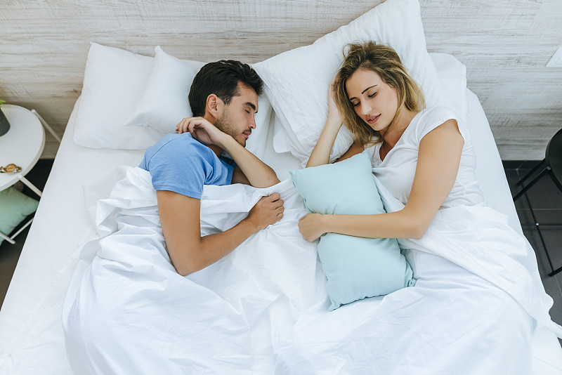 高角度的夫妇睡在床上在家里的卧室图片素材