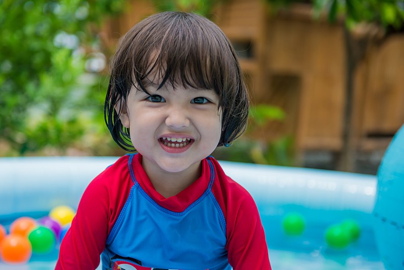 游泳池里微笑的男孩的肖像图片素材