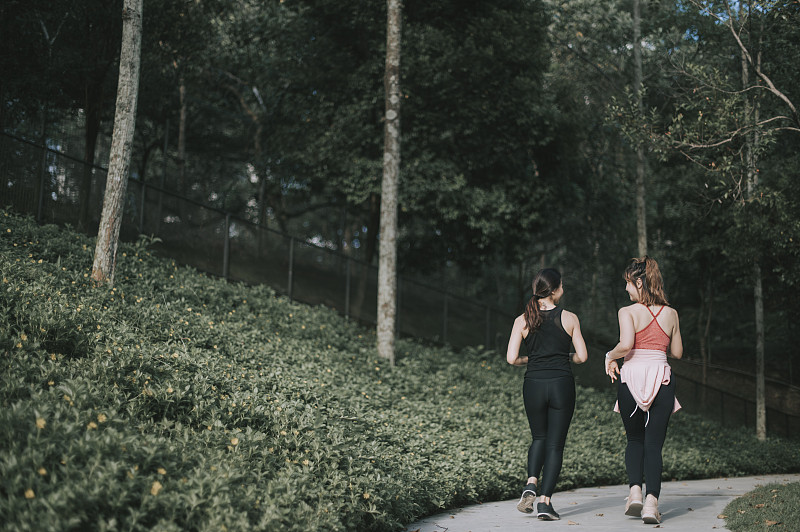 周末晚上在公园里跑步的亚洲华人女性图片素材