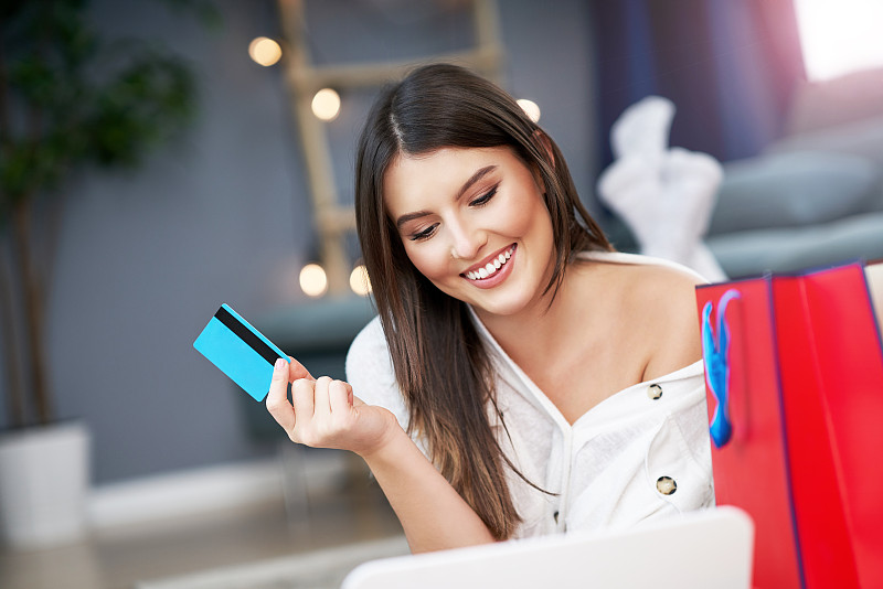 用信用卡在家网上购物的漂亮女人图片下载