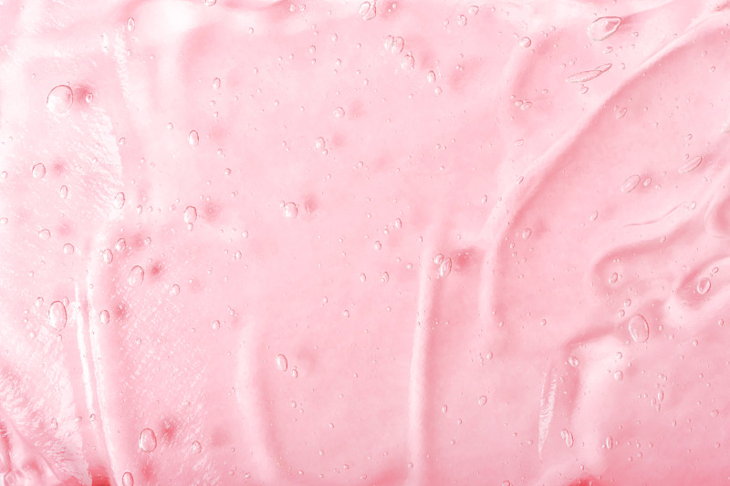 透明保湿精华液涂抹于粉色背景上。透明质酸保湿。抗菌凝胶泡沫。化妆和皮肤护理的化妆品。美容。图片下载