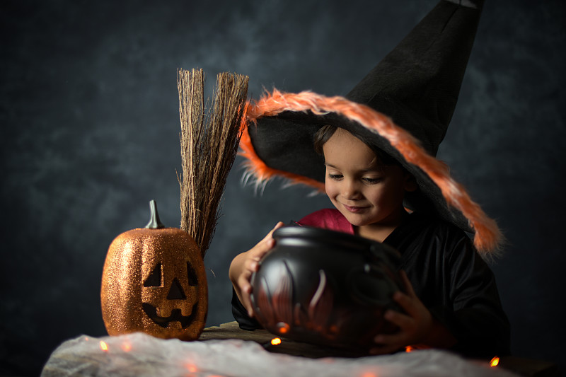 在万圣节的场景中，一个装扮成巫师的小孩图片下载