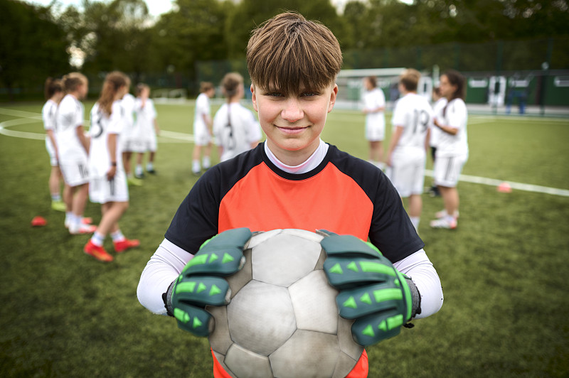 一个十几岁的女孩足球队的守门员肖像在运动场上图片下载
