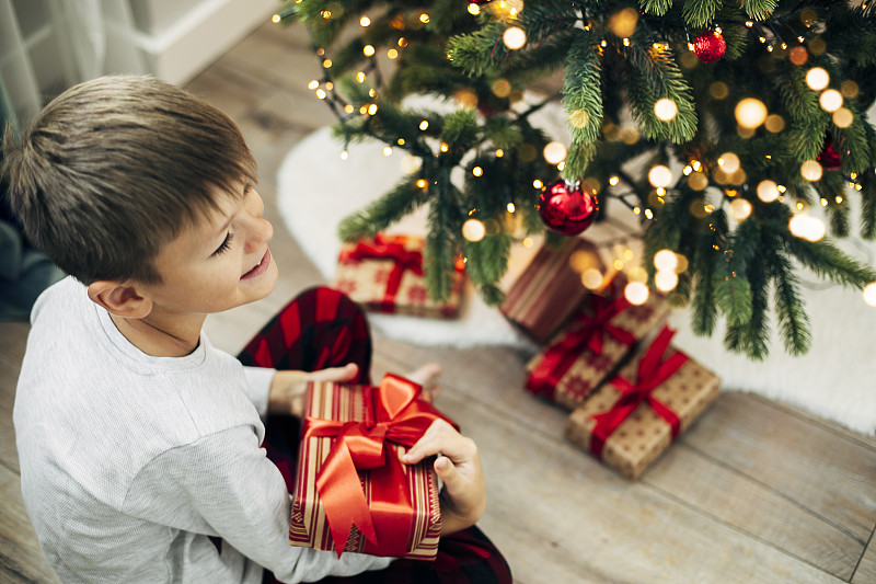 快乐微笑的男孩7-8岁打开圣诞礼物图片下载