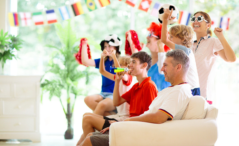 一群足球迷在家里看电视。图片下载
