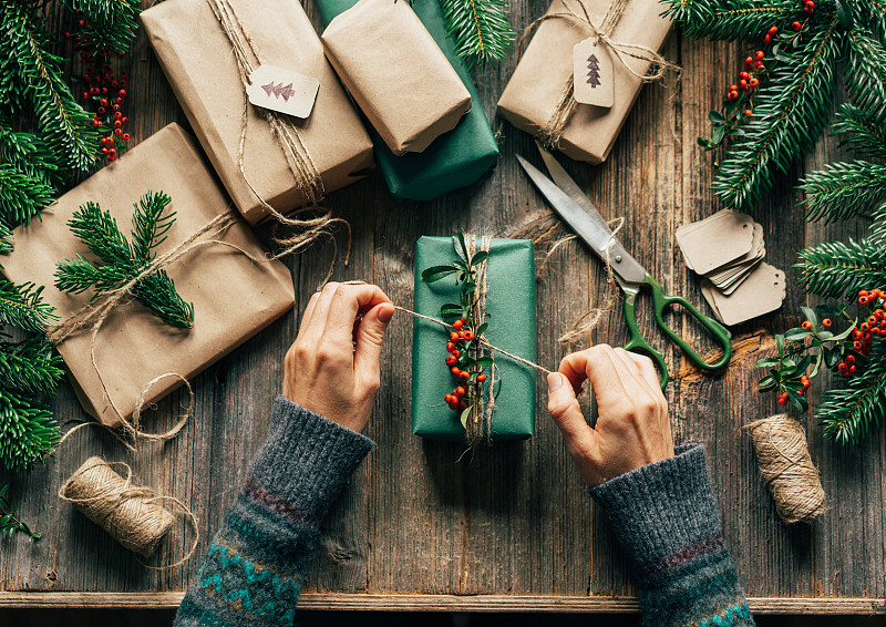 俯视图妇女的手包裹手工圣诞礼物。图片下载