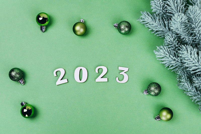 2023年，圣诞玩具和云杉枝上的绿色表面。图片下载
