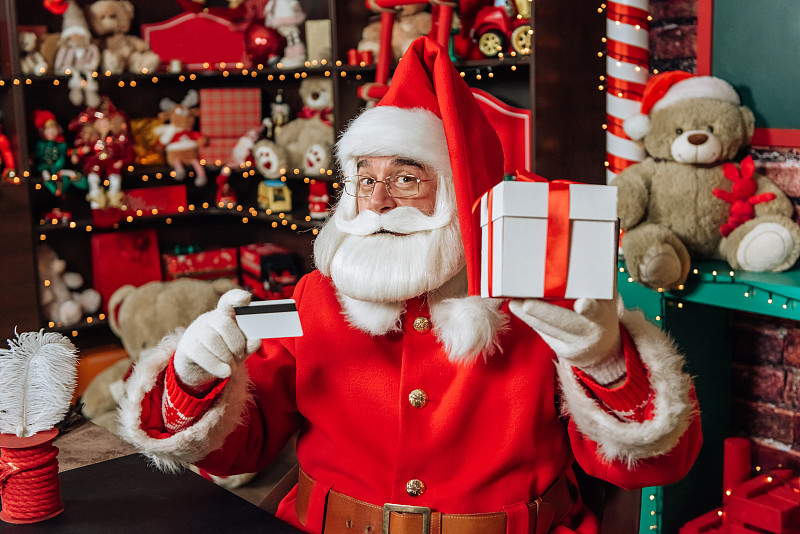 圣诞老人拿着信用卡和圣诞礼物图片下载