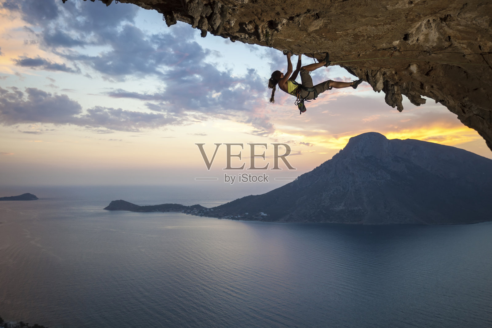 日落时的年轻女性攀岩者照片摄影图片