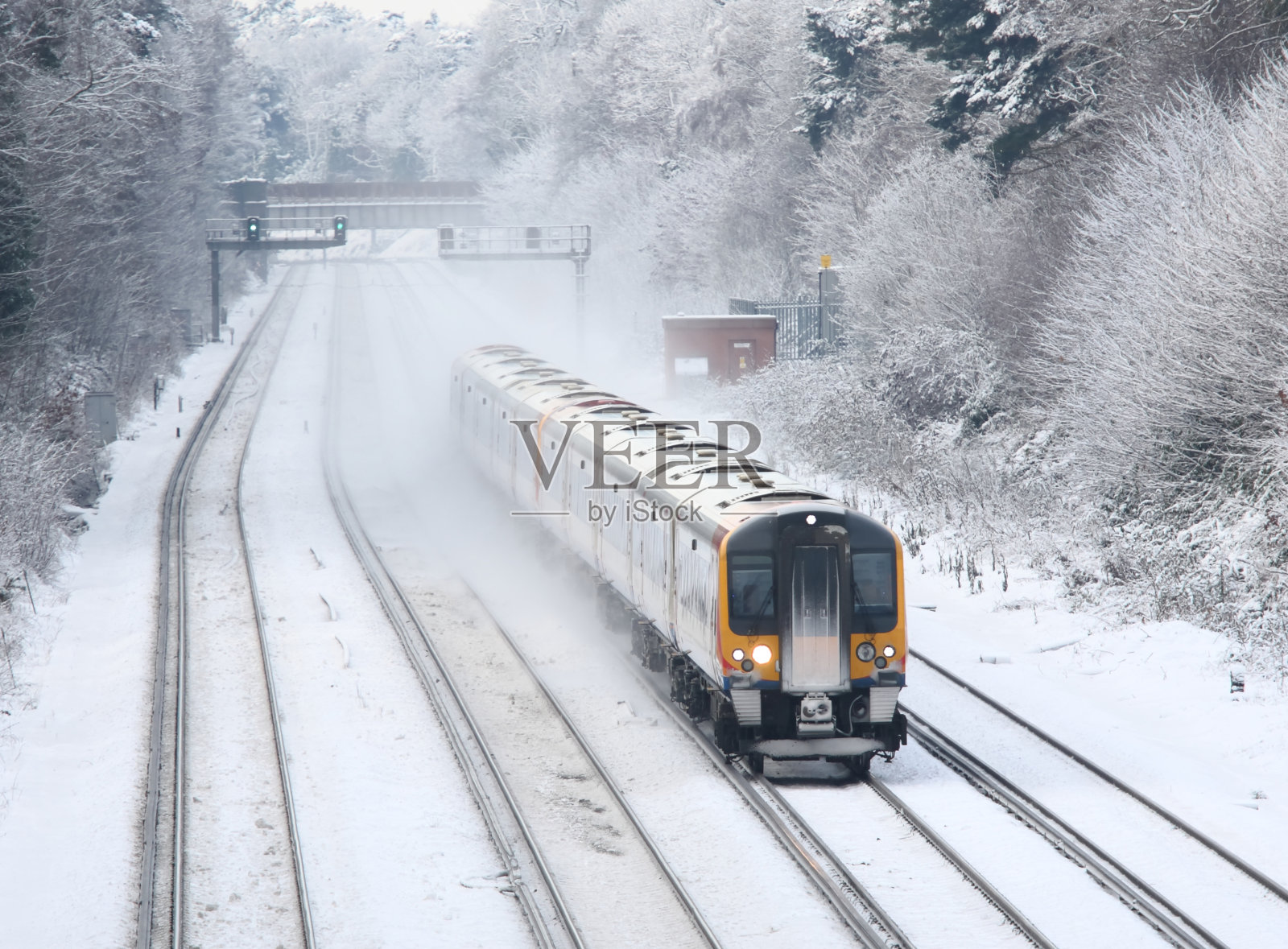 在冬天的冰雪中运送通勤者到伦敦的火车照片摄影图片