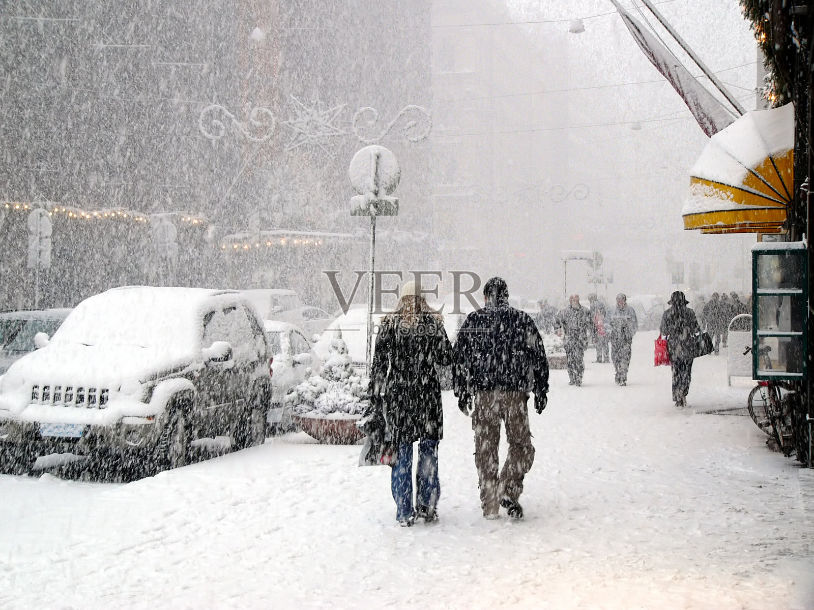 人们在暴风雪中走在城市的人行道上照片摄影图片