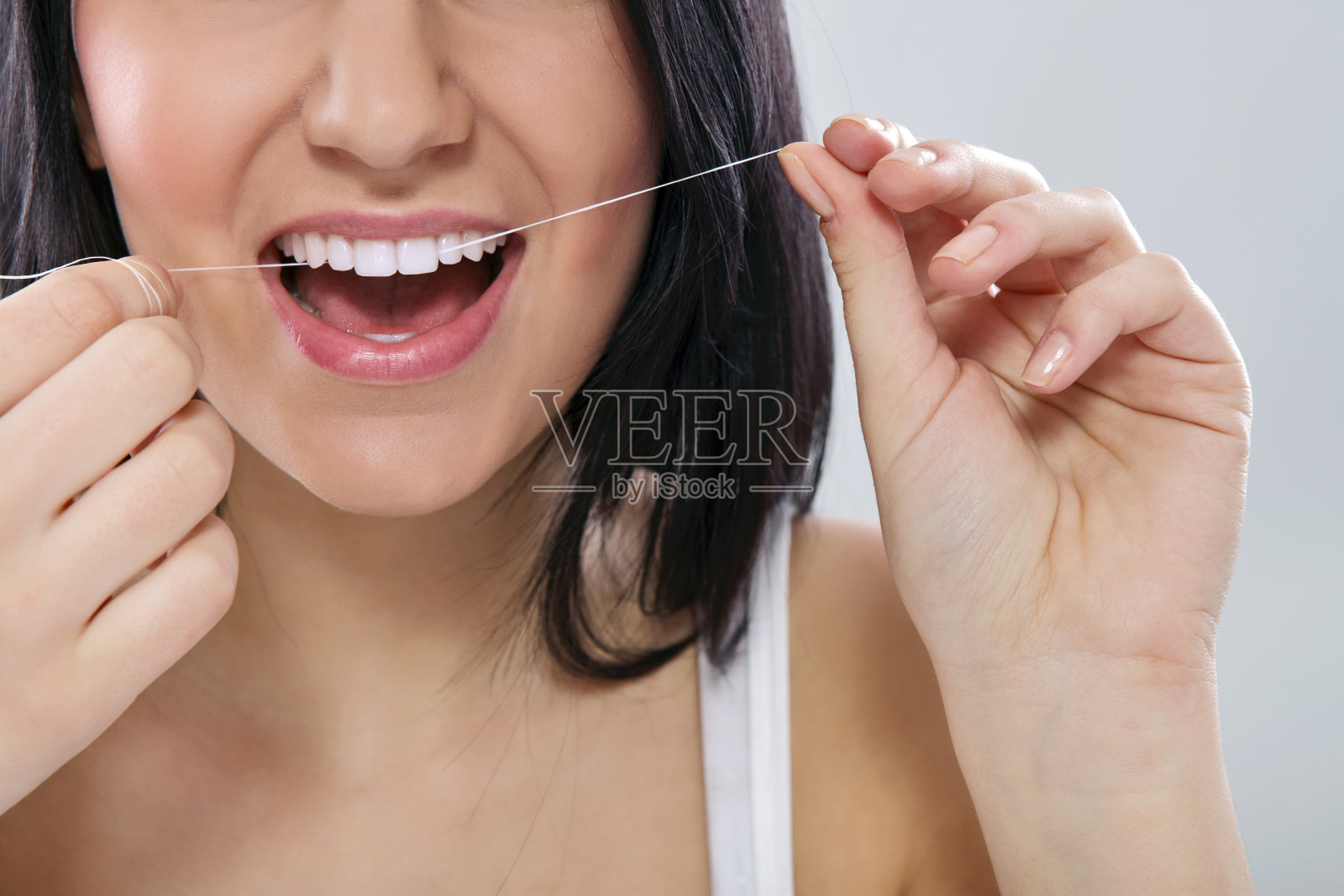 女人微笑和用牙线剔牙的下半张脸照片摄影图片