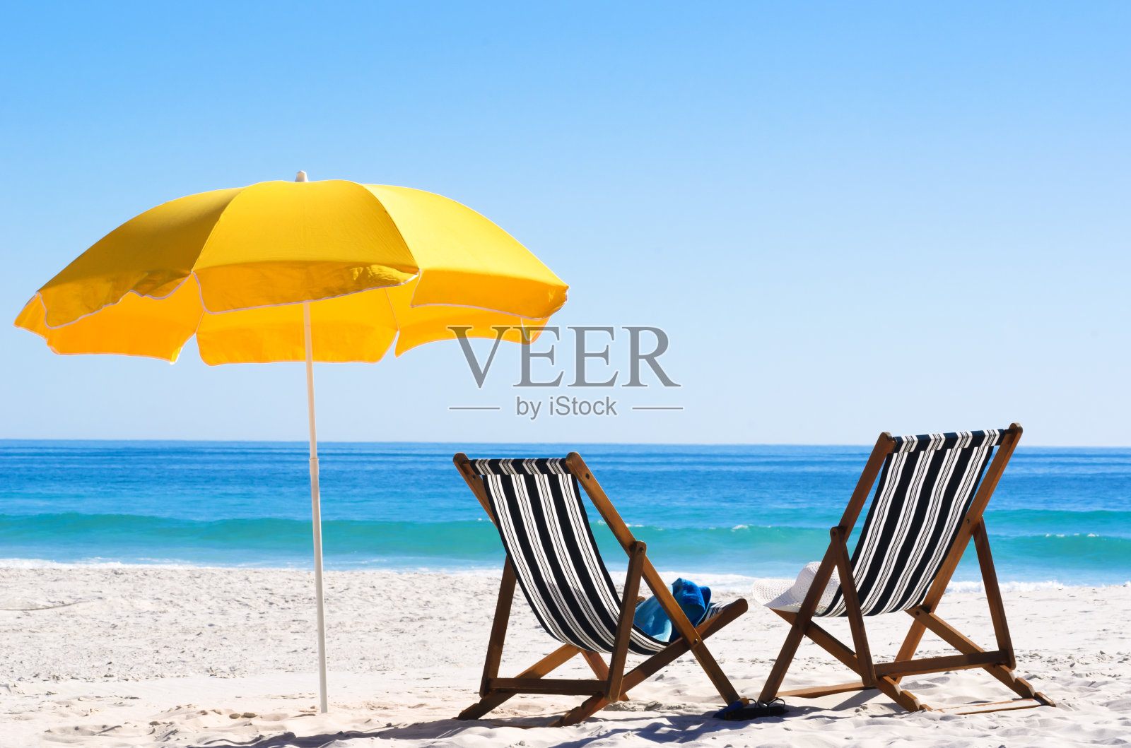 沙滩上的两把沙滩椅和一把黄色雨伞照片摄影图片