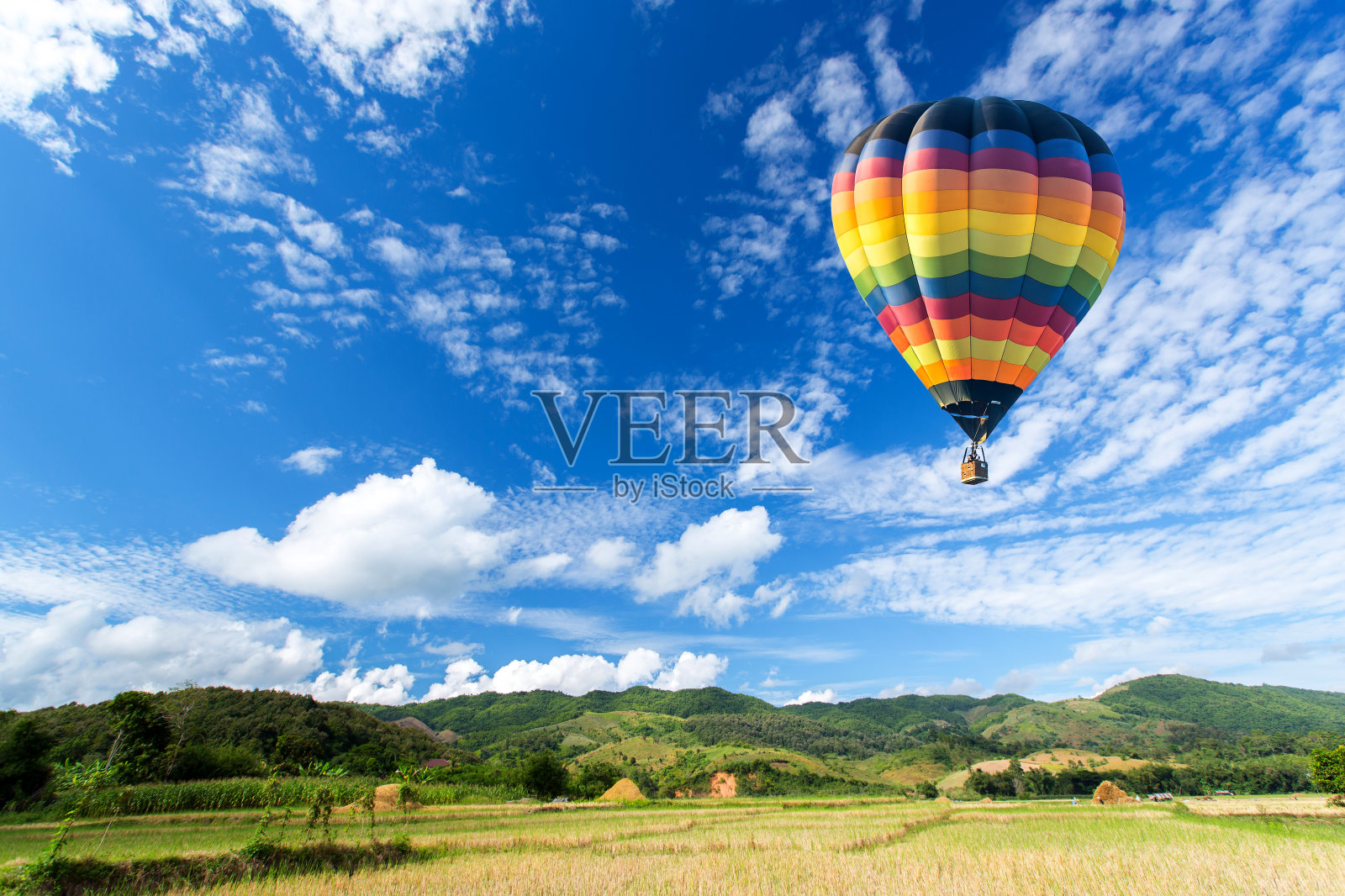 彩色的热气球飞过绿色的田野和蓝色的天空照片摄影图片