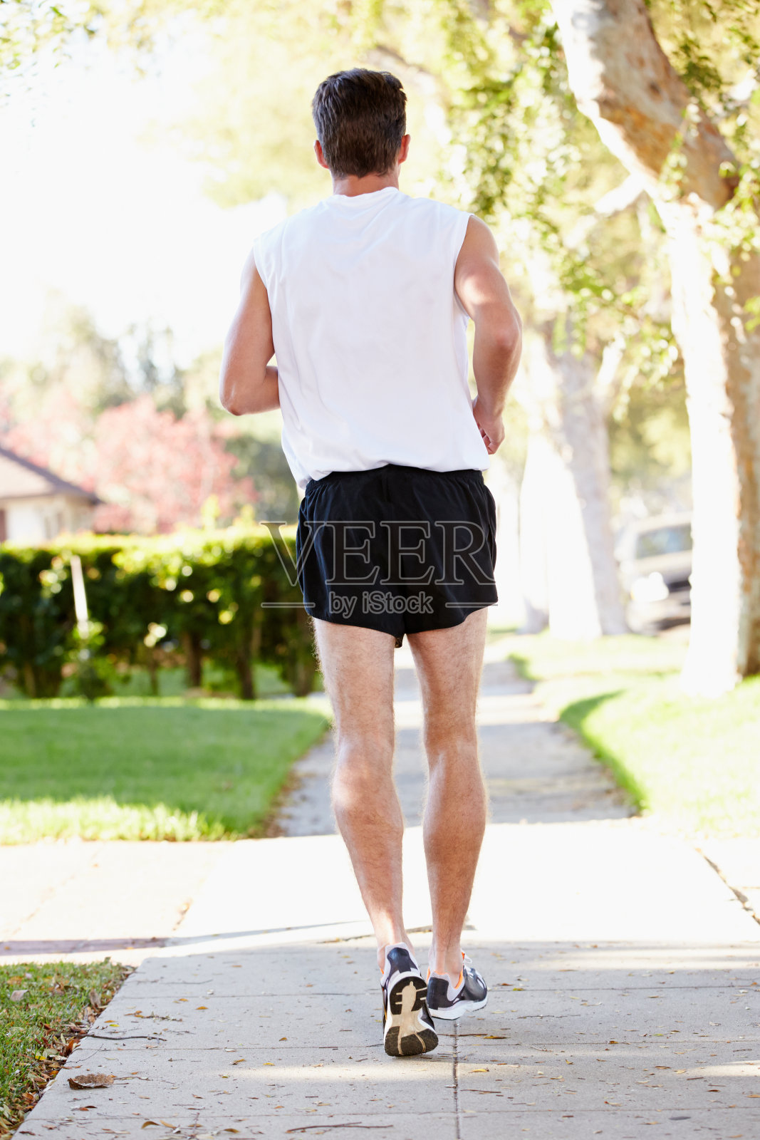 男性跑步者在郊区街道上锻炼的后视图照片摄影图片