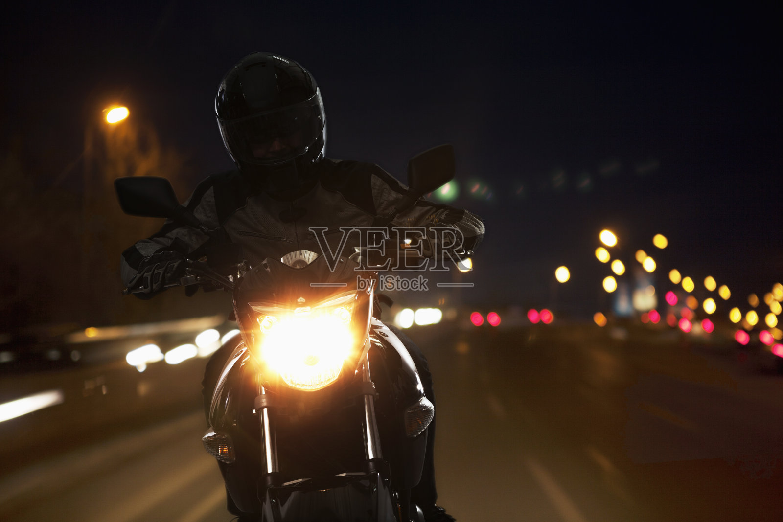 一个晚上骑摩托车的年轻人照片摄影图片