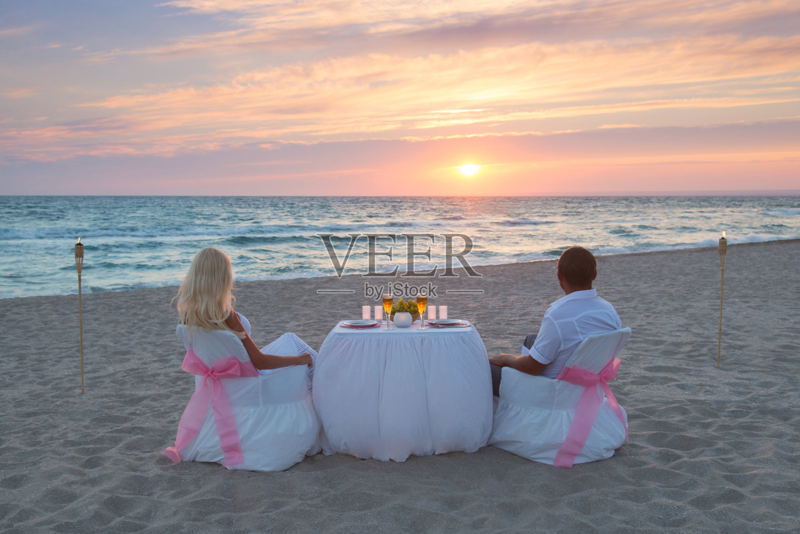 一对情侣在海滩上吃烛光浪漫晚餐照片摄影图片