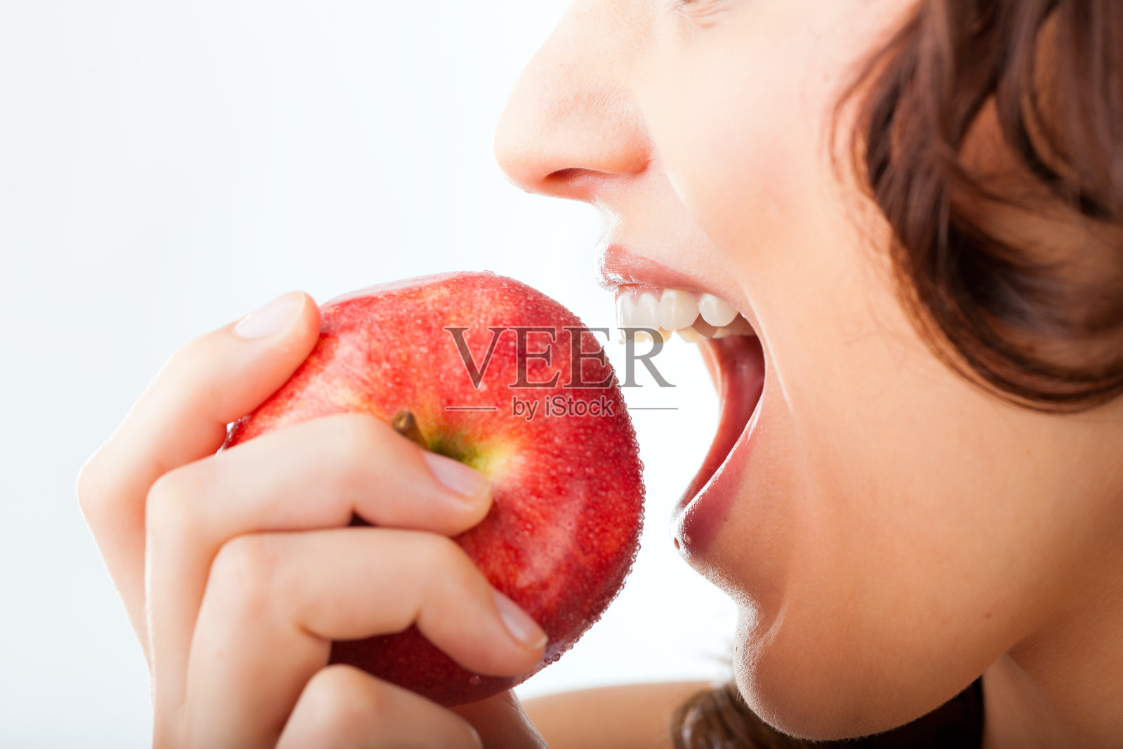 年轻女子咬了一口苹果照片摄影图片