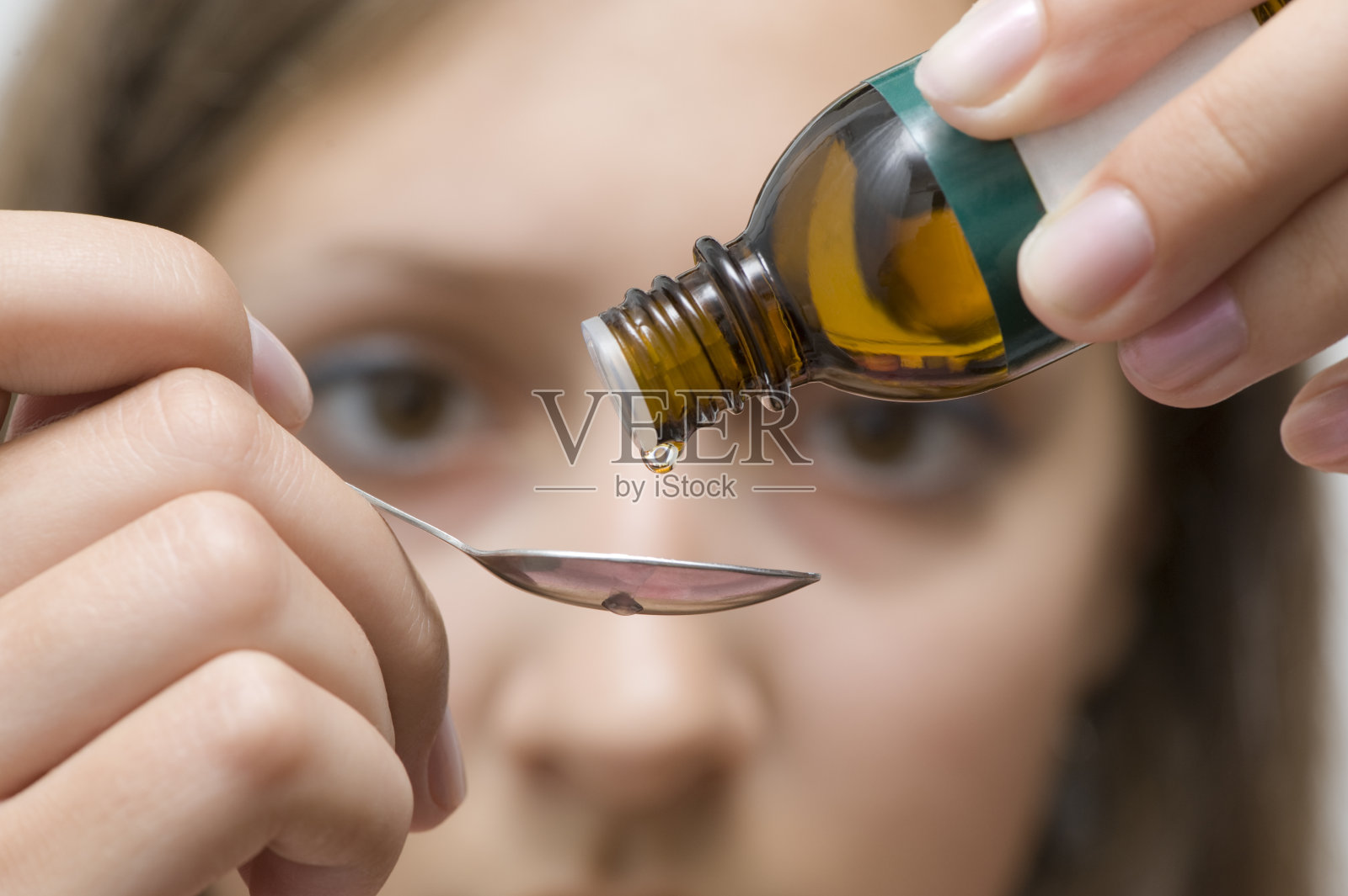 棕色眼睛的女人正试着正确地给一种草药剂量照片摄影图片