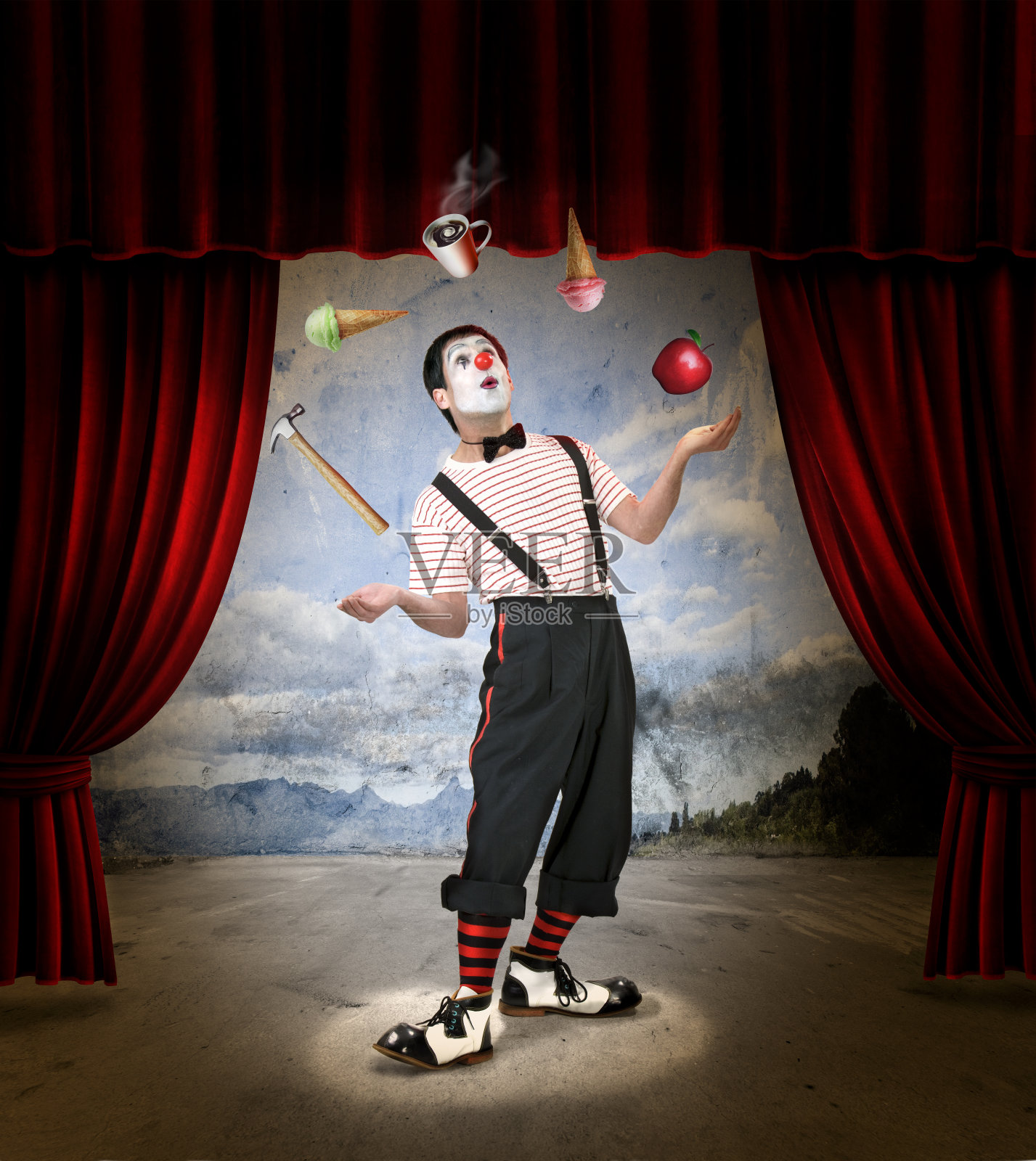 一个在冰淇淋、咖啡、苹果和锤子之间杂耍的小丑照片摄影图片