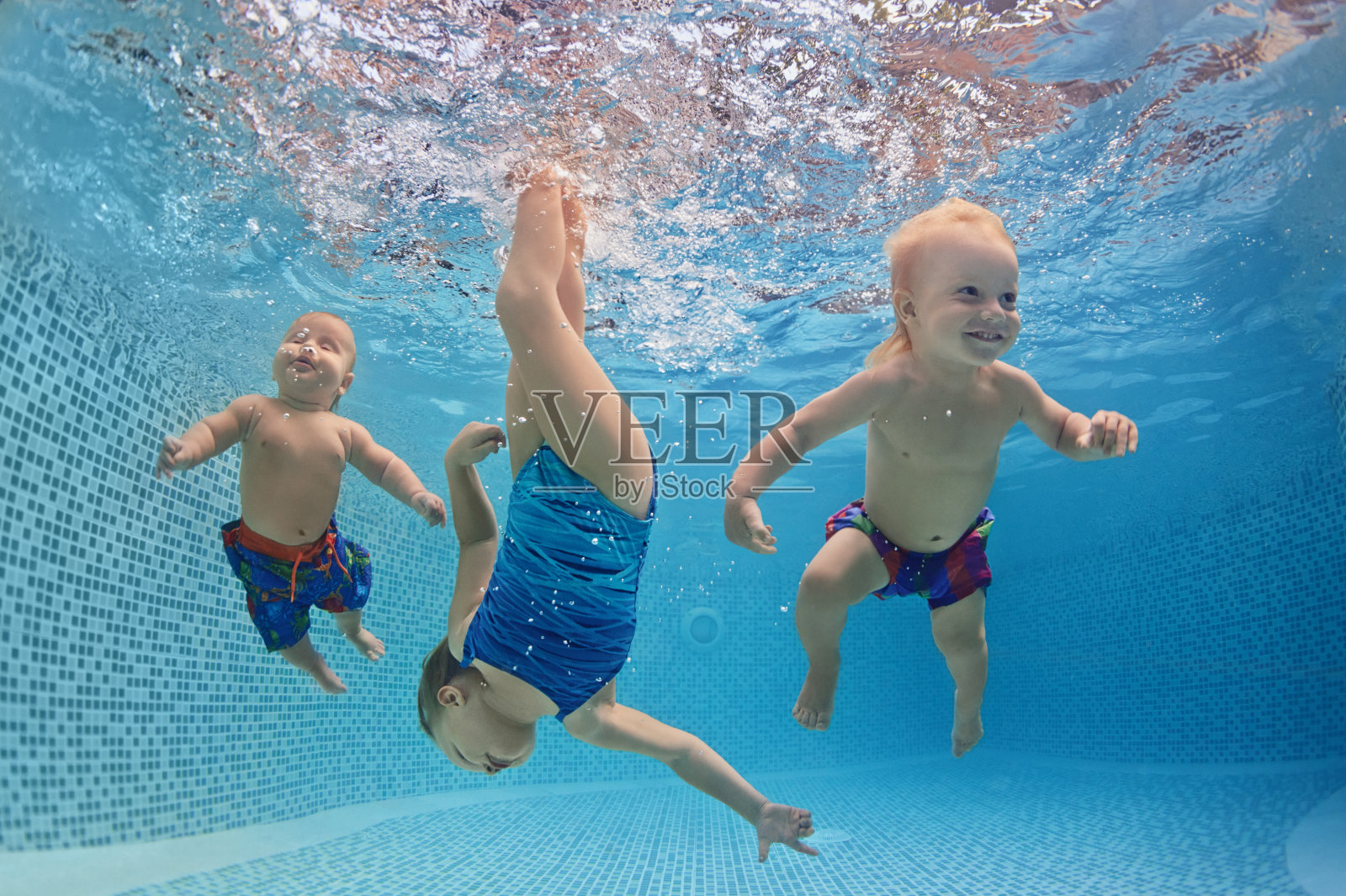 孩子们在游泳池里游泳和潜水，玩得很开心照片摄影图片