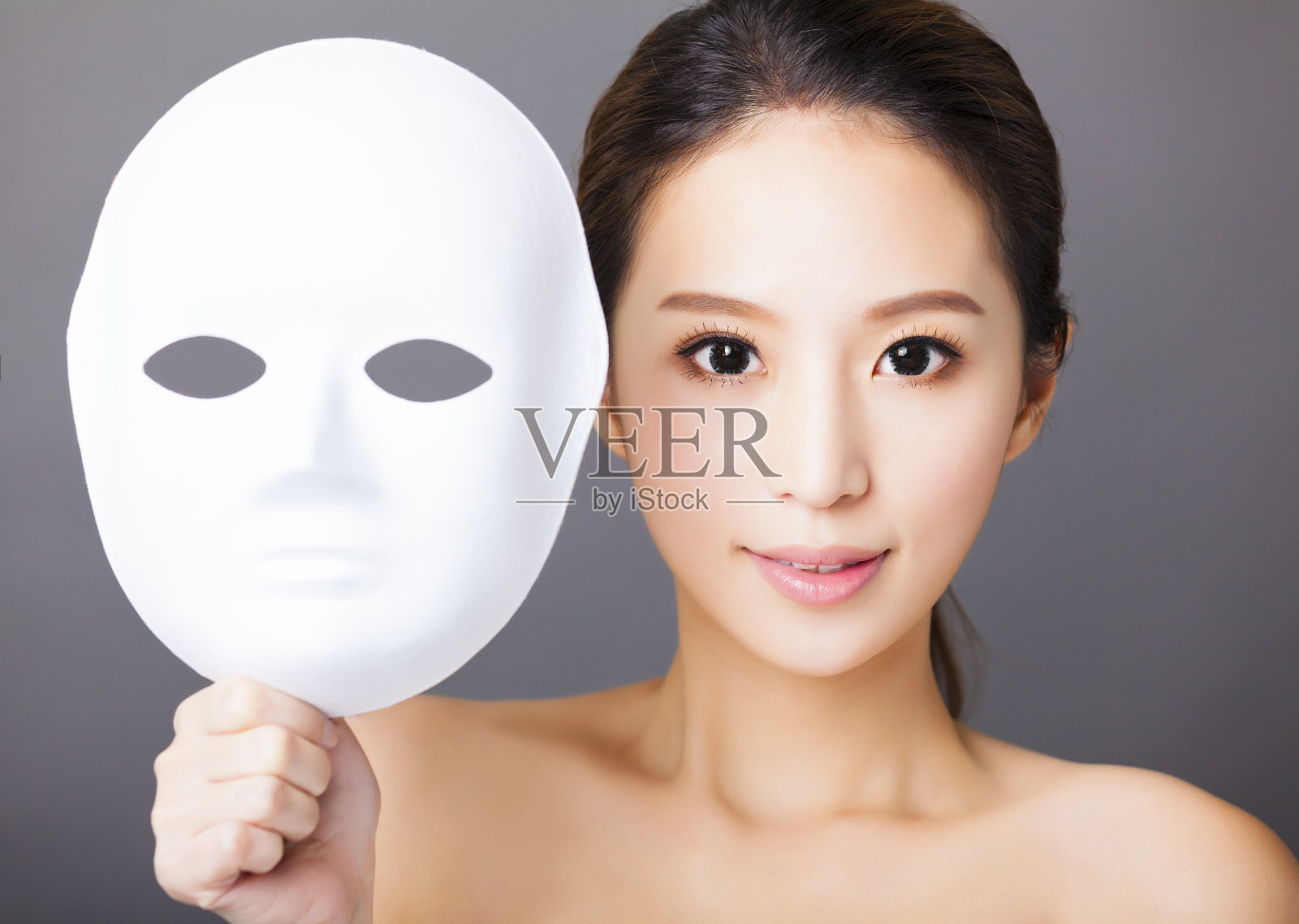 年轻女子手持白色面具为医疗美容概念照片摄影图片