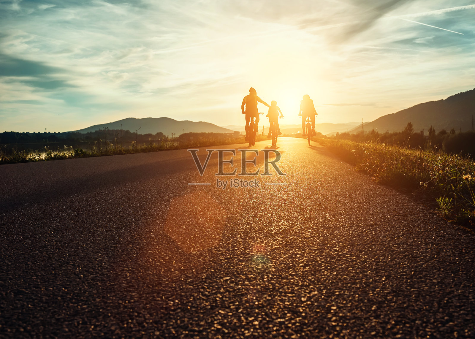 Сyclists一家人在日落时分的路上旅行照片摄影图片