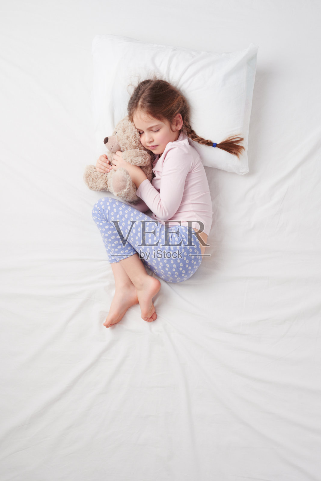 俯视图小女孩和泰迪熊睡觉照片摄影图片