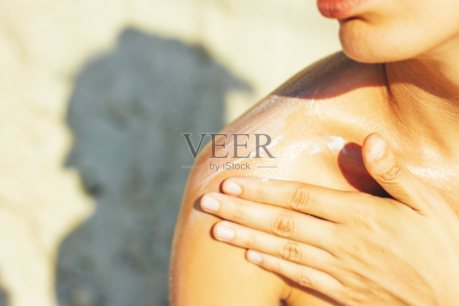 妇女在太阳晒伤的皮肤上涂霜照片摄影图片