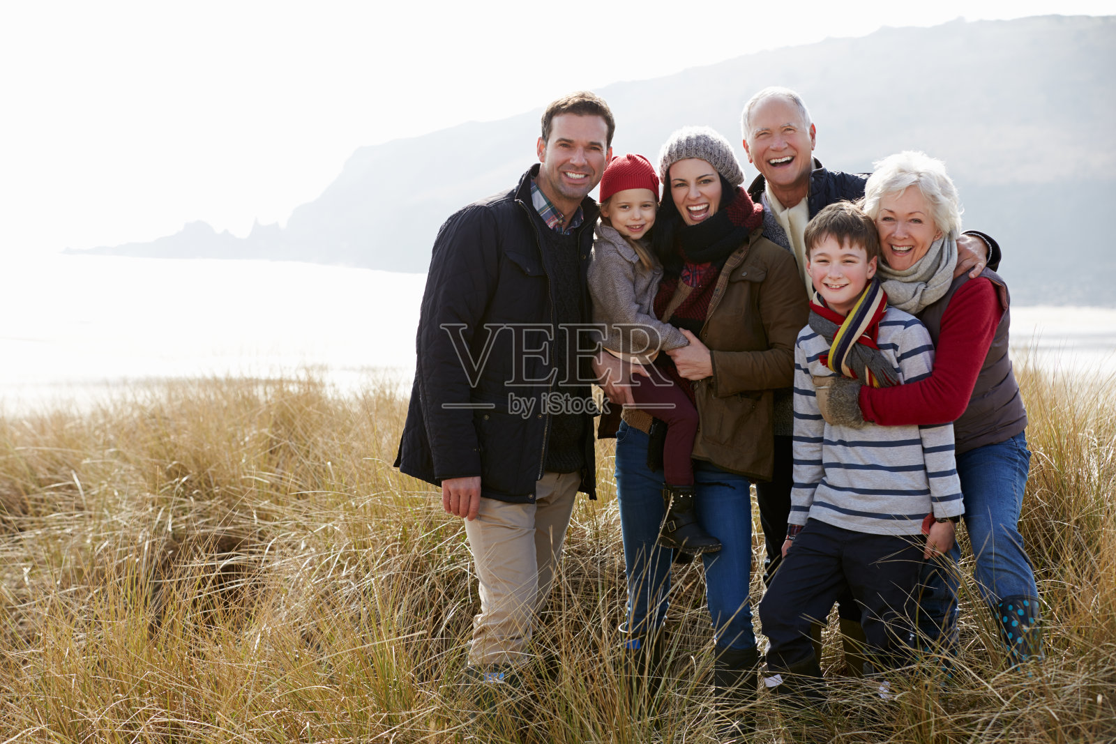冬季海滩沙丘中的多代家庭照片摄影图片