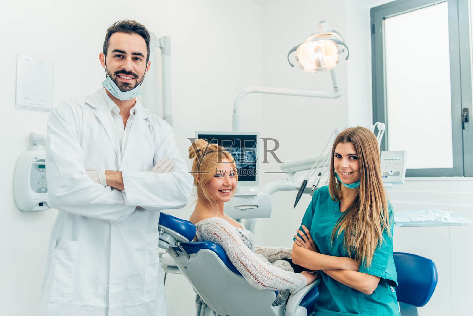 男牙医、他的助手和牙科诊所的女病人照片摄影图片