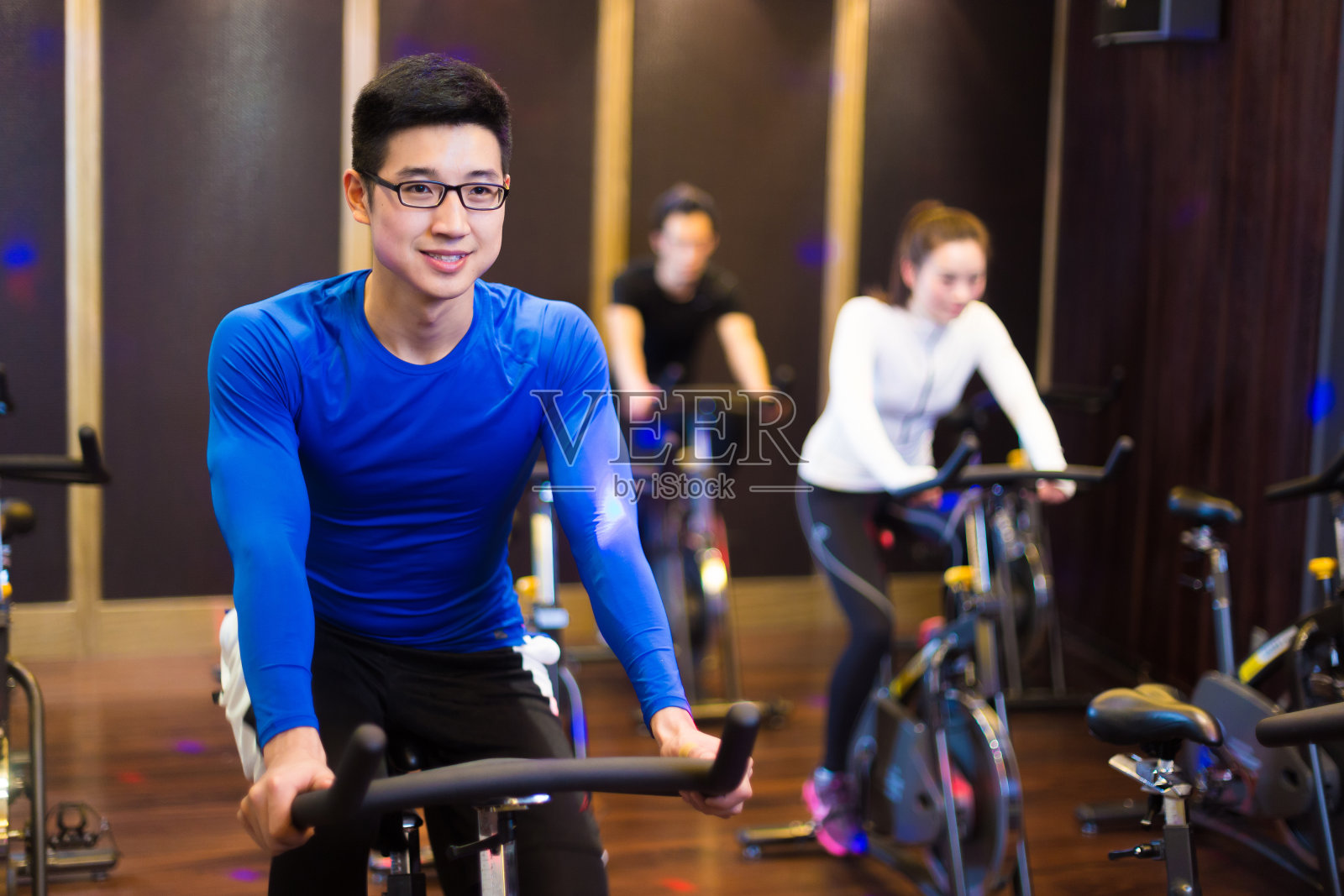 亚洲年轻人在现代健身房锻炼照片摄影图片
