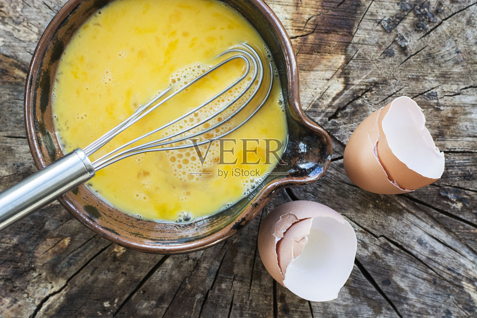 将鸡蛋打匀，放入陶瓷碗中搅拌照片摄影图片