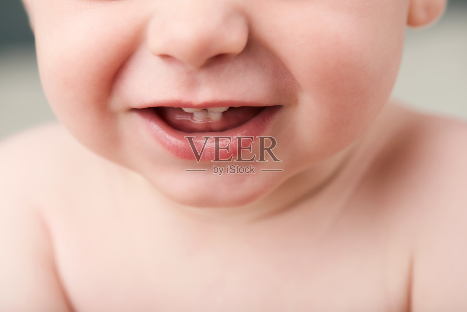 婴儿的嘴紧凑，露出了他的第一颗牙齿照片摄影图片