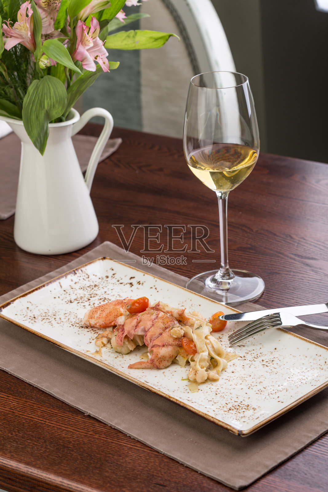 意大利面配龙虾和一杯白葡萄酒照片摄影图片