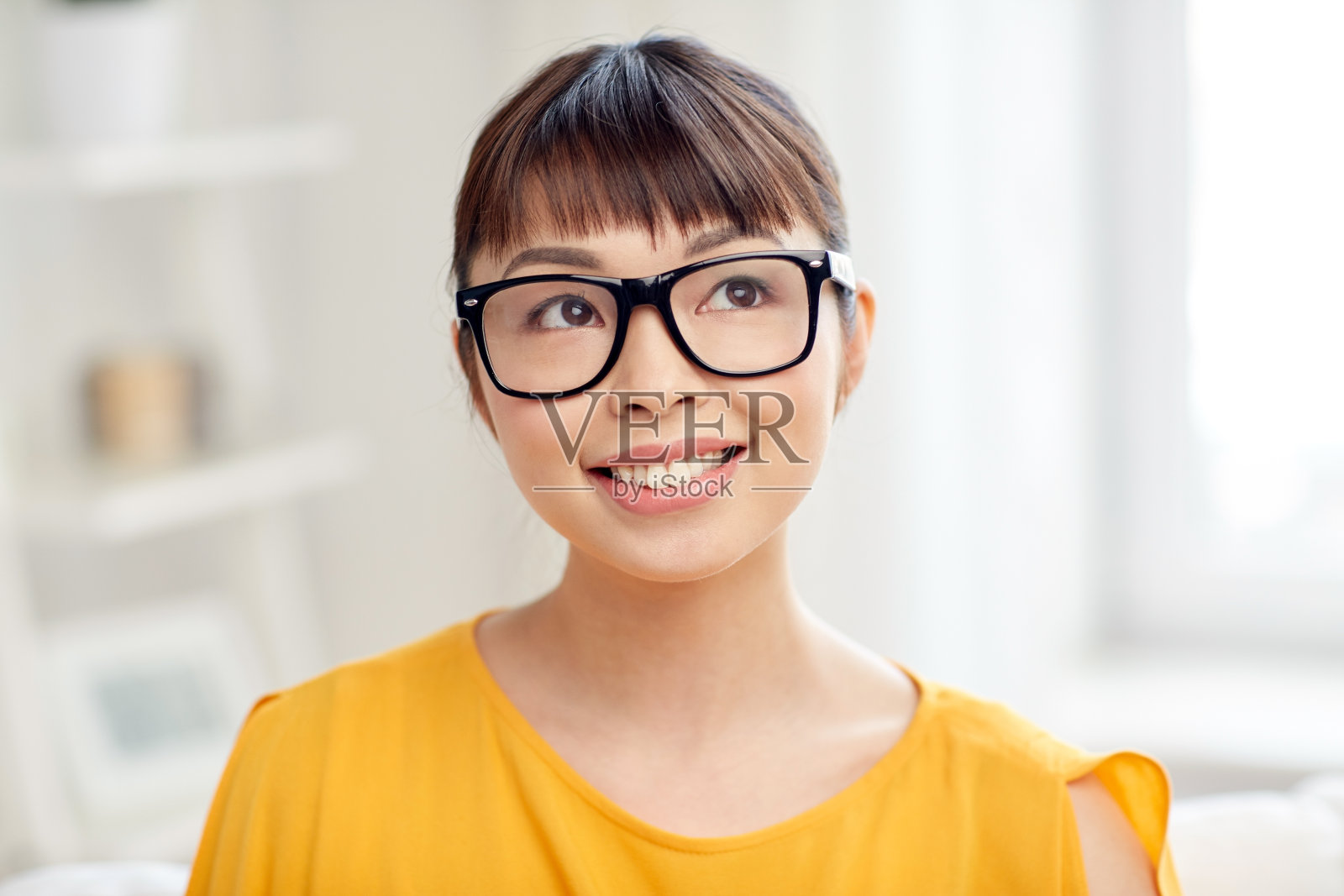 快乐的亚洲年轻女子戴眼镜在家照片摄影图片