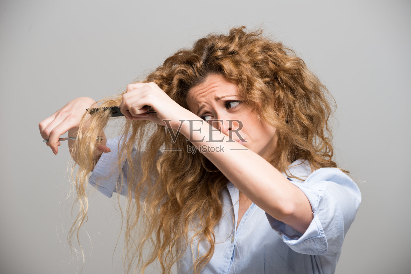 剪自己头发的女人照片摄影图片