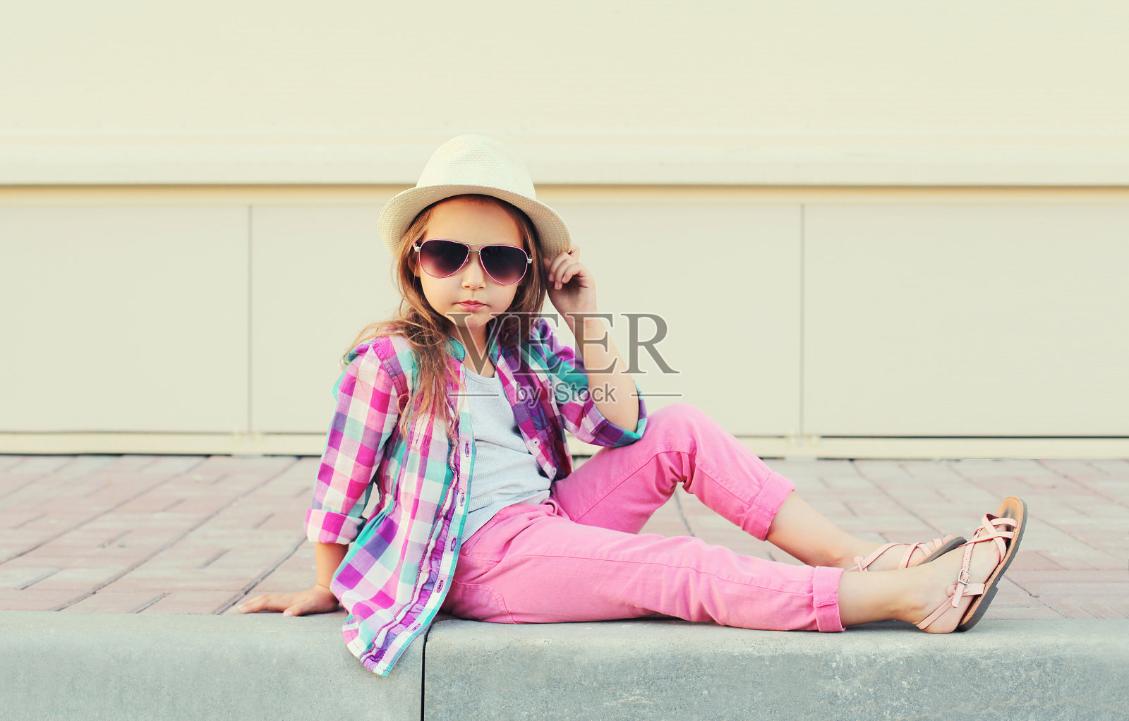 穿着衬衫、帽子和太阳镜的时尚小女孩模特照片摄影图片