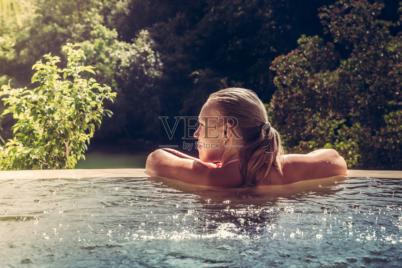 女人放松在酒店游泳池看风景照片摄影图片