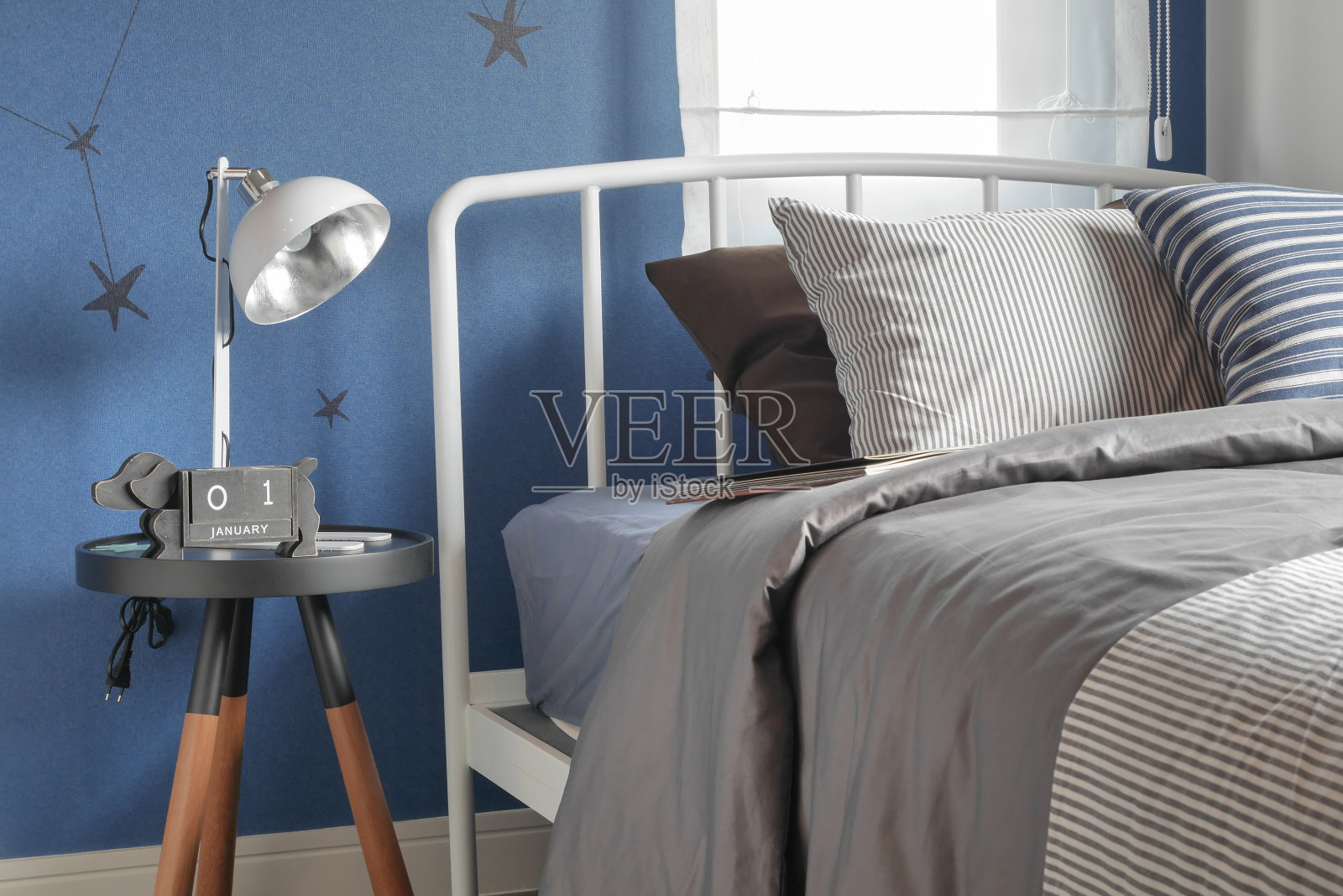 现代床上的条纹枕头和蓝色的墙壁照片摄影图片